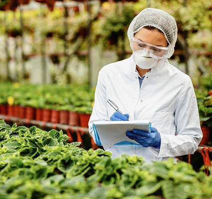 una cientifica con tapabocas y gorro listando vegetales